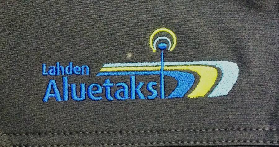 Lahden Aluetaksin logo brodeerattuna tummaan kankaaseen