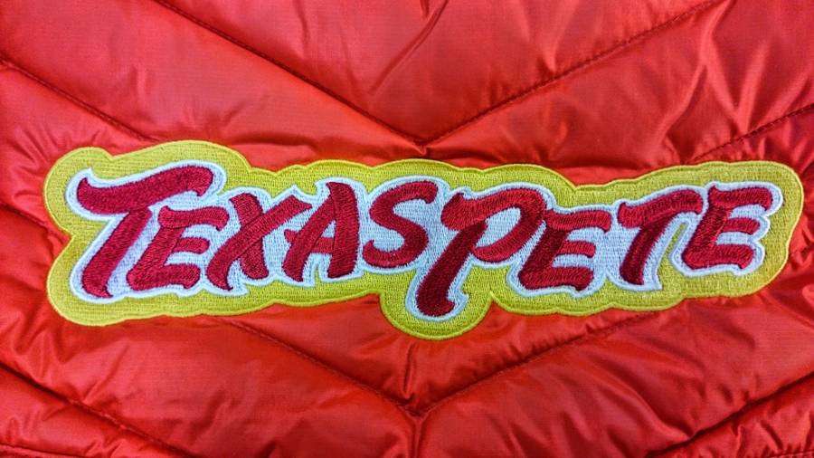 Brodeerattu tekstimerkki punaisessa takissa